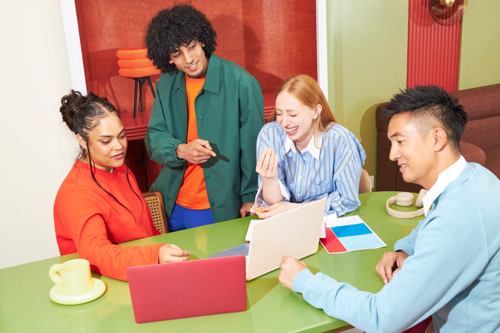 A small team working together around a table with laptops
